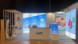 Grand stand d'exposition avec panneaux lumineux, grand comptoir modulable et arche effet bois